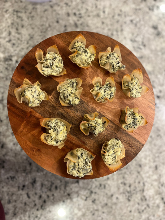 spinach artichoke bites in wontons on a wooden pedastal