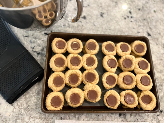 Reeses mini peanut butter cup cookies on a baking sheet in mini silicone baking cups